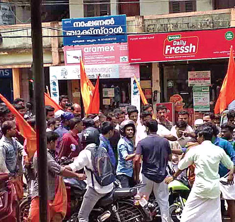 RSS activists assault a biker in Malappuram on Thursday during a rally organised in protest against the recent attack on its office in Munduparamba | express