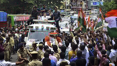 AICC President Rahul Gandhi waves at his supporters during a road show ahead of the Karnataka Assembly election in Bengaluru on Wednesday. | PTI