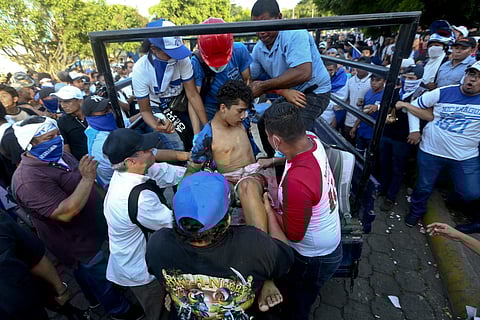 In this May, 30, 2018 photo, a man who was shot and wounded is loaded on the back of a pick-up truck to get medical attention during a march against Nicaragua's President Daniel Ortega in Managua, Nicaragua. | AP