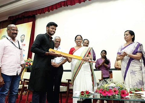 Health Minister K K Shylaja hands over a bat to cricketer Sanju V Samson during the state-level observation of World No Tobacco Day at AMCHSS on Thursday