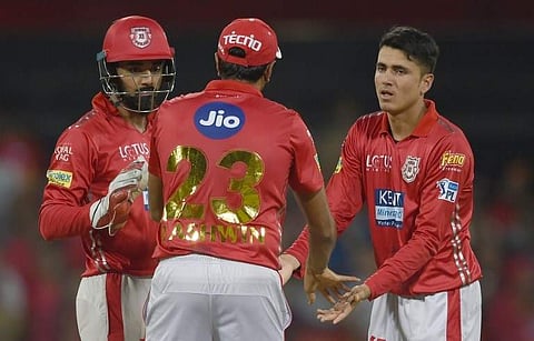 Kings XI Punjab cricketer Mujeeb Zadran (R) is congratulated by captain Ravichandran Ashwin and KL Rahul after taking the wicket of Rajasthan Royals cricketer Jos Buttler during the 2018 Indian Premier League (IPL) T20 match between Kings XI Punjab and Ra