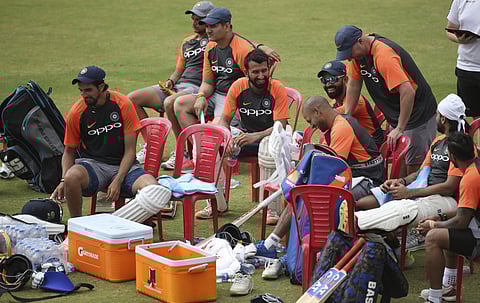 Support staff and players of the Indian cricket team take a break during a practice session ahead of a one-off test match against Afghanistan in Bangalore. | AP