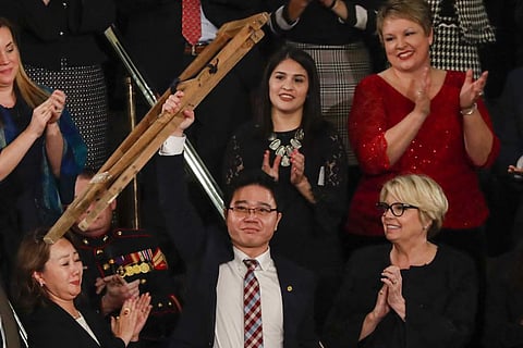 In this Jan. 30, 2018, file photo, Ji Seong-ho, a North Korean defector, holds up his crutches after his introduction by President Trump during the State of the Union address to a joint session of Congress on Capitol Hill in Washington. President Donald T