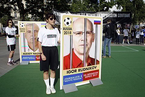 Members of Reporters Without Borders (RSF) hold giants portraits representing imprisoned Russian journalists, on Place de la Republique, in Paris. | AP