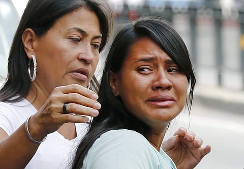 Barbara Barca, right, a survivor of the stampede at a crowded nightclub, cries as she leaves police headquarters in Caracas, Venezuela. | AP
