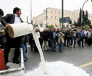 Protesting farmers pour milk on a street in front of the Greek Parliament during a demonstration against low dairy prices in central Athens. AP