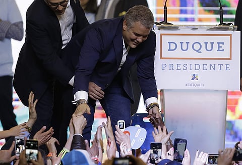 President Elect Ivan Duque shakes hands with supporters after his victory in the presidential runoff election in Bogota. (Photo: AP)