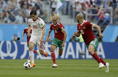 Iranian forward Sardar Azmoun dribbling past Moroccan defenders (File| AP)