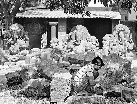 An artisan carving stones to make statues at Keshana village in Mayurbhanj district
