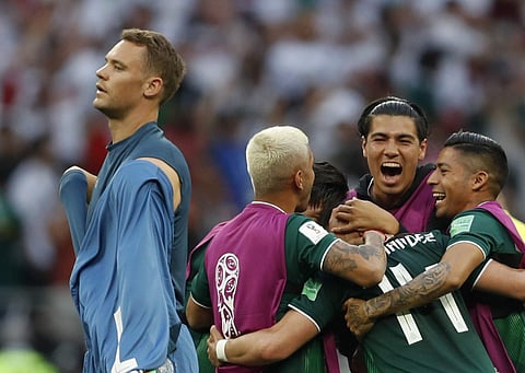 Germany goalkeeper Manuel Neuer walks past as Mexico players celebrate after defeating Germany 1-0 in their group F match at the 2018 soccer World Cup in the Luzhniki Stadium in Moscow, Russia, Sunday, June 17, 2018. | AP