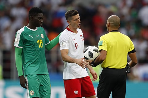 Poland's Robert Lewandowski, center, speaks with Referee Nawaf Shukralla from Bahrain end of the group H match between Poland and Senegal at the 2018 soccer World Cup in the Spartak Stadium in Moscow, Russia, Tuesday, June 19, 2018. | AP
