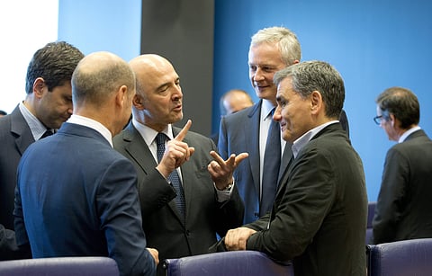 Greek Finance Minister Euclid Tsakalotos, right, speaks with European Commissioner for Economic and Financial Affairs Pierre Moscovici, second left, during a meeting of eurogroup finance ministers at EU headquarters in Luxembourg. (Photo|AP)