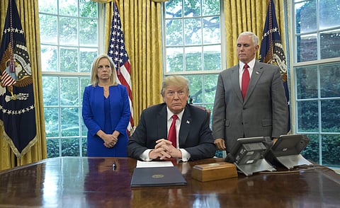 President Donald Trump, center, with Homeland Security Secretary Kirstjen Nielsen, left, and Vice President Mike Pence, right, before signing an executive order to end family separations at the border, during an event in the Oval Office of the White House