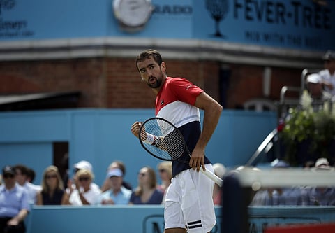 Croatia's Marin Cilic celebrates winning the first set against Australia's Nick Kyrgios during their semifinal tennis match at the Queen's Club tennis tournament in London. (AP)
