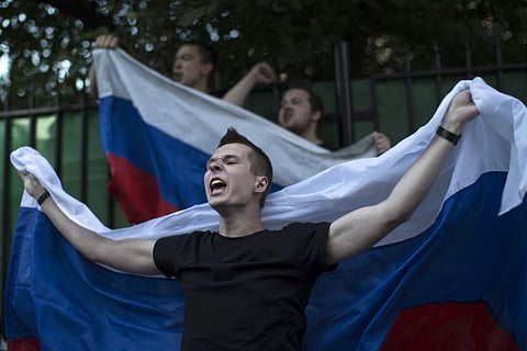 Russian soccer fans cheer waving Russian national flags while gathered on Nikolskaya Street, a favorite meeting place for fans from different countries, during the 2018 soccer World Cup in Moscow, Russia, Saturday, June 23, 2018. | AP
