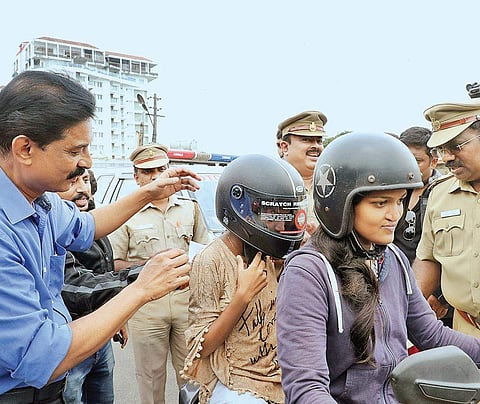 Deputy Transport Commissioner Shaji Joseph giving a helmet to a pillion rider as part of the helmet awareness project jointly organised by MVD and Freedom Riders in Kochi on Saturday | Melton Antony