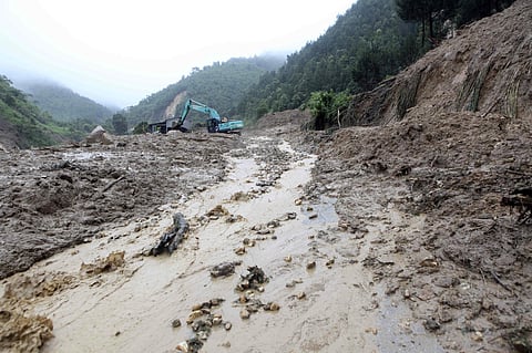 In this Sunday, June 24, 2018, photo, authorities clear mud from a landslide that blocked a road in Lai Chau province, Vietnam. | AP