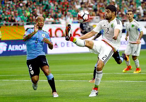 Mexico defender Nestor Araujo (2) kicks the ball as Uruguay midfielder Carlos Sanchez defends during the first half of a Copa America group C soccer match at University of Phoenix Stadium in Glendale, Ariz. |AP