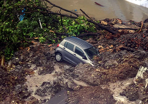 A car struck in debris after a wall collapsed at a construction site in Antop Hill Wadala East area in Mumbai. (Photo | PTI)