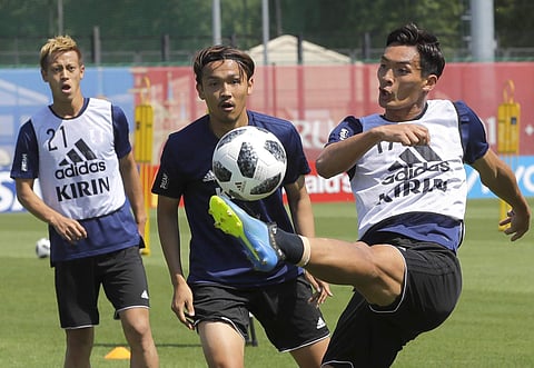 Japan's Tomoaki Makino, right, Takashi Usami, center, and Keisuke Honda practice during the official training at the Rubin Stadium in Kazan, Russia. (AP)