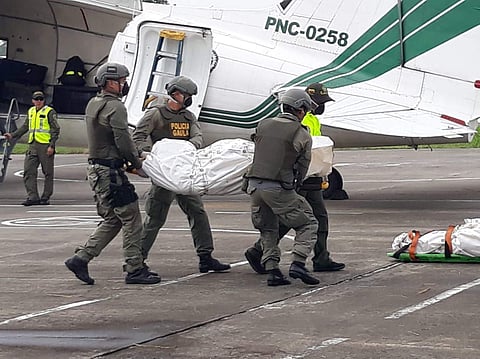 In this handout photo provided by the Colombian National Police, police carry the body of one of three Ecuadorean press workers kidnapped and killed in the conflictive border region with Ecuador, as they arrive to the airport in Palmira, Colombia, Friday,