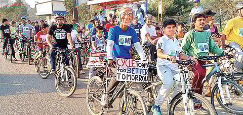 Murali Kartik (wearing the mask) cycles down city roads to spread awareness on cycling