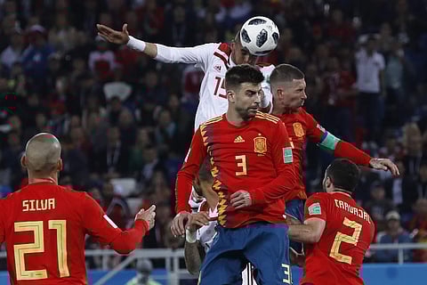 Morocco's Youssef En Nesyri, top, scores his side's second goal in spite of Spanish efforts to stop him | AP