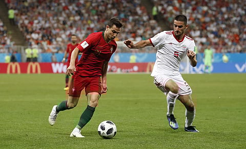 Portugal's Cedric, left, vies for the ball with Iran's Milad Mohammadi during the group B match between Iran and Portugal at the 2018 soccer World Cup at the Mordovia Arena in Saransk, Russia, Monday, June 25, 2018. | AP