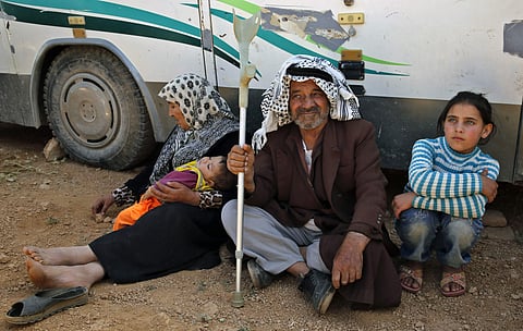 Mohammed Suleiman Darwish, 76, sits with his wife, Baseema Darwish, and their granddaughter Israa, right, as they wait to cross into Syria from the eastern Lebanese border town of Arsal, Lebanon, Thursday, June 28, 2018. Baseema will be staying in Lebanon