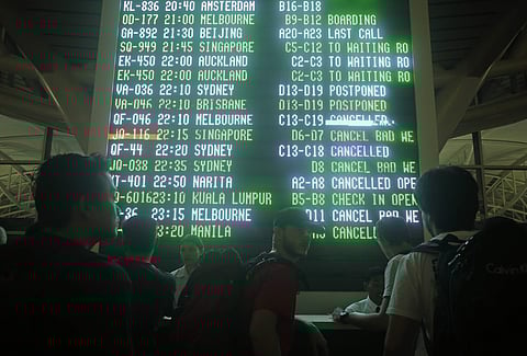 Passengers looks at an information board at Bali's international airport, Indonesia on Thursday, June 28, 2018, as airlines canceled flights. | Associated Press