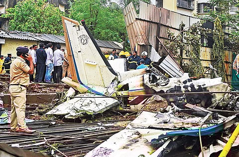Rescue personnel stand near the debris of the chartered plane that crashed in Ghatkopar, Mumbai, killing five persons, on Thursday | pti