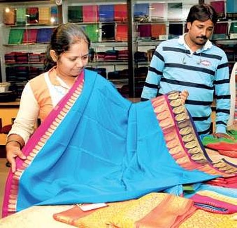 A woman having a look at a Mysuru Silk saree at KSIC in Mysuru | Express