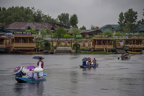People travel in a boat to cross Dal Lake during heavy rainfall in Srinagar on Friday June 29 2018. | PTI