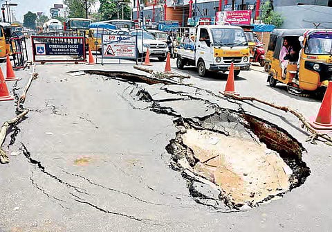 A recently laid BT road caved in at Shapurnagar crossroads, in Hyderabad on Friday. Traffic police had a tough time regulating the traffic and diverting hundreds of vechiles through other routes| R Satish Babu