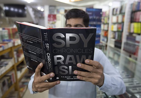 A Pakistani customer looks at a book 'Spy Chronicles' at a book store in Islamabad. | AP