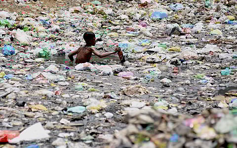 A rag picker collects recyclable items from a sewage drain canal full of garbage near Taimur Nagar slum area in New Delhi. ( File photo | EPS/ Parveen Negi