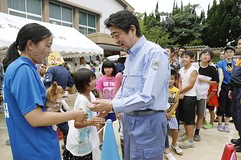 Japanese Prime Minister Shinzo Abe talks with children evacuated to an evacuation center in Kurashiki, Okayama prefecture, southwestern Japan. ( Photo | AP )