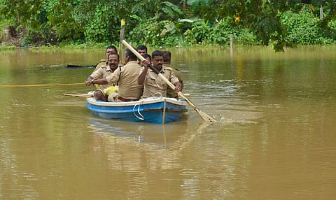 Police personal at Panamaram Station in Wayanad rowing a fibre boat to reach the station. (Photo | EPS/Manu R Mavelil)
