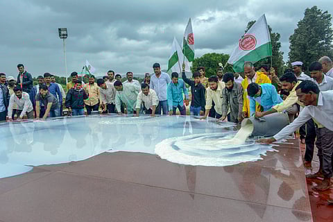 Swabhimani Shetkari Sanghatana activists pour milk at the memorial of Maharashtra's first Chief Minister late Y B Chavan during a protest to demand direct Rs 5/- subsidy per liter and waiver of GST for butter and milk powder in Karad Maharashtra on Monday