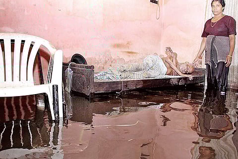 Etty Joseph, of Thengaparambil house, who is paralysed waist down, in his inundated house at Illikkal | Vishnu Prathap