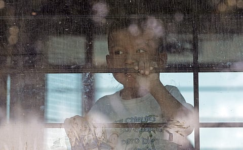 An immigrant child looks out from a U.S. Border Patrol bus. (Photo | AP)