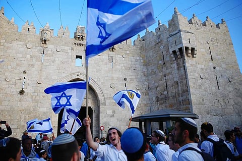Israelis wave national flags outside the Old City's Damascus Gate, in Jerusalem. (File | AP)