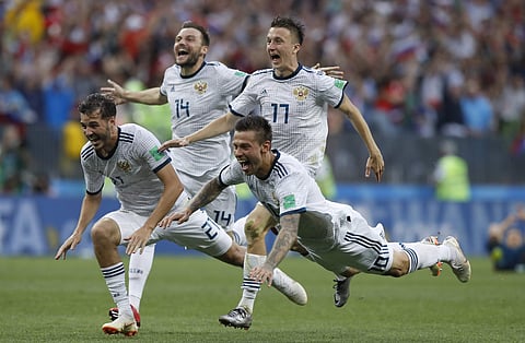 Russia's Fyodor Smolov, right, dives as he celebrates with teammates after Russia defeated Spain in a penalty shoot out during the round of 16 match between Spain and Russia. (Photo | AP)