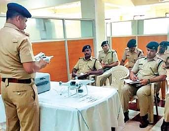 A RPF cop trained in operating a drone instructing others in its operations