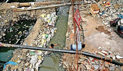 People crossing a nala which has been left unattended by GHMC officials in Rahmath Nagar junction | vinay madapu