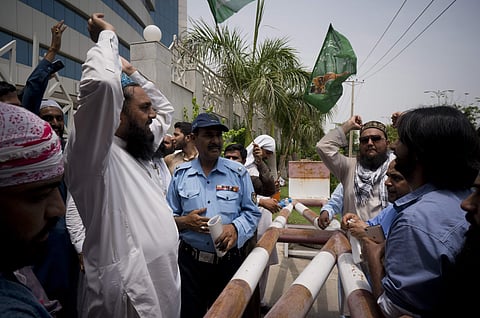 In this Monday, July 9, 2018 photo, supporters of Pakistani radical, religious and sectarian groups protest outside the office of the Pakistan Electronic Media Regulatory Authority, demanding that their election campaigns to be aired by media channels, in