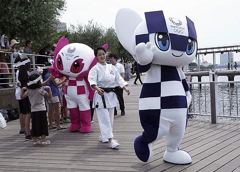 Tokyo 2020 Olympic mascot 'Miraitowa' and Paralympic mascot 'Someity' pose for photographers after their water parade with town's landmark 'Rainbow Bridge' as background. (Photo | AP)