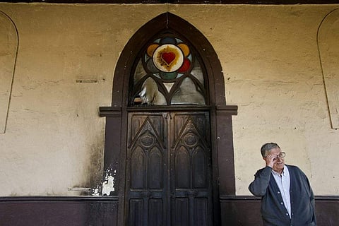 Priest Modesto Nunez, of the Corazon de Jesus Catholic Church, speaks in front of his church's door that was damaged in an overnight firebomb attack in Santiago, Chile, Monday, Jan. 22, 2018. | Associated Press