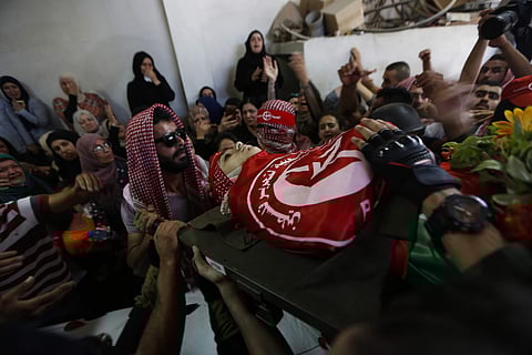 Palestinian mourners carry the body of Arkan Mezeher, 15, during his funeral in Deheisha refugee camp, near the West Bank city of Bethlehem, Monday, July 23, 2018. | AP