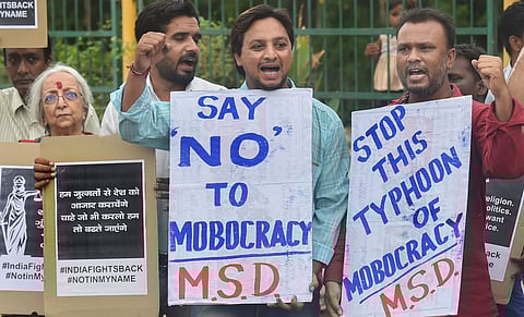 People raise slogans and hold placards as they protest against mob lynching. (Photo | PTI)